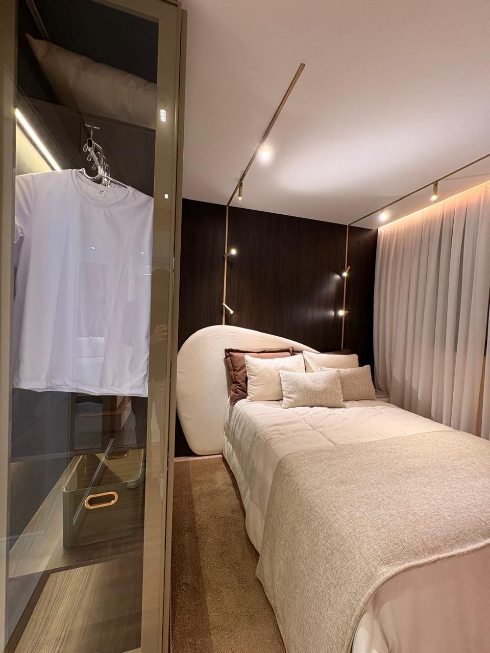 Dormitório com cama de casal e closet com porta de vidro