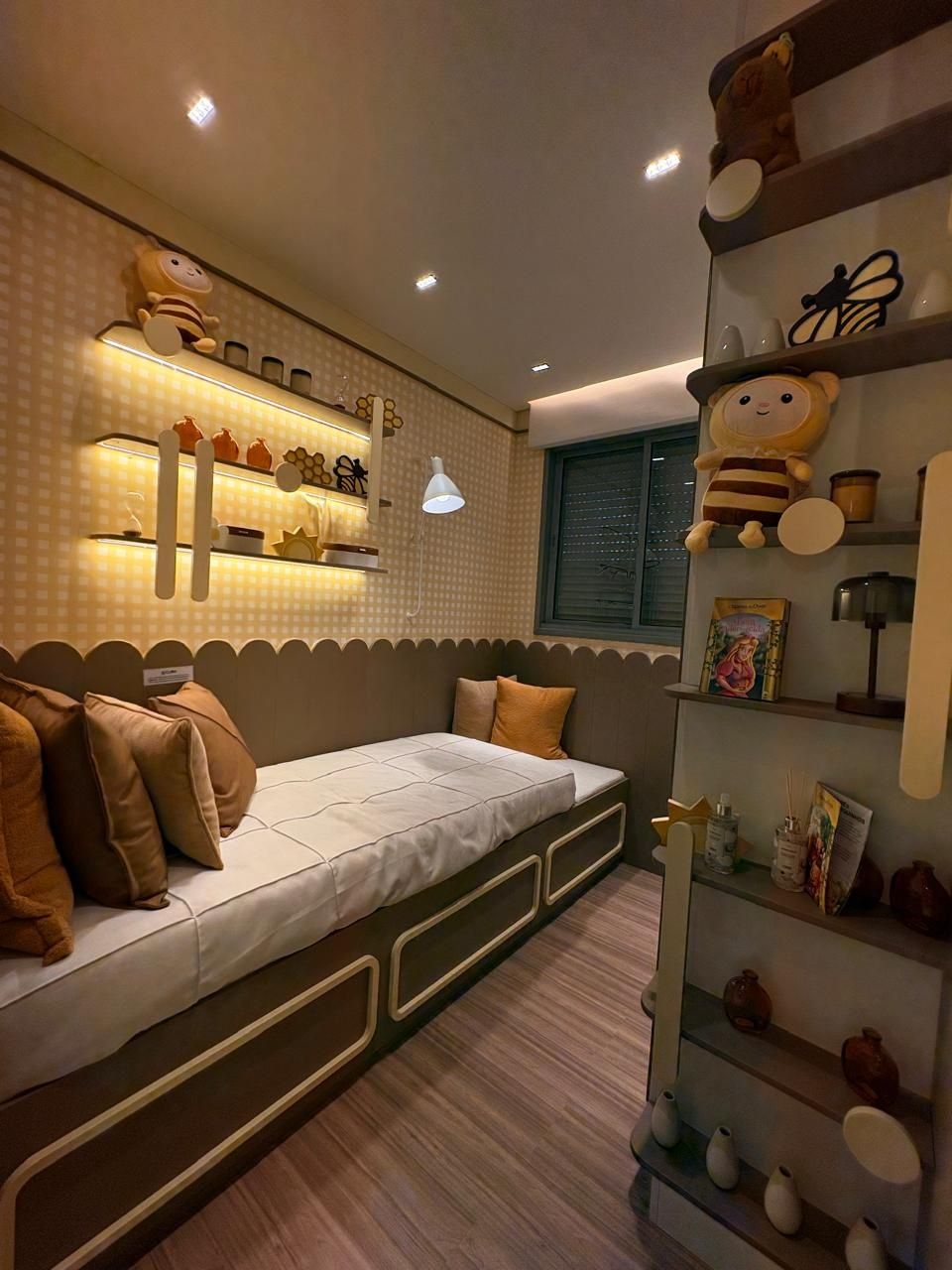 Dormitório com cama de solteiro, prateleiras e iluminação indireta